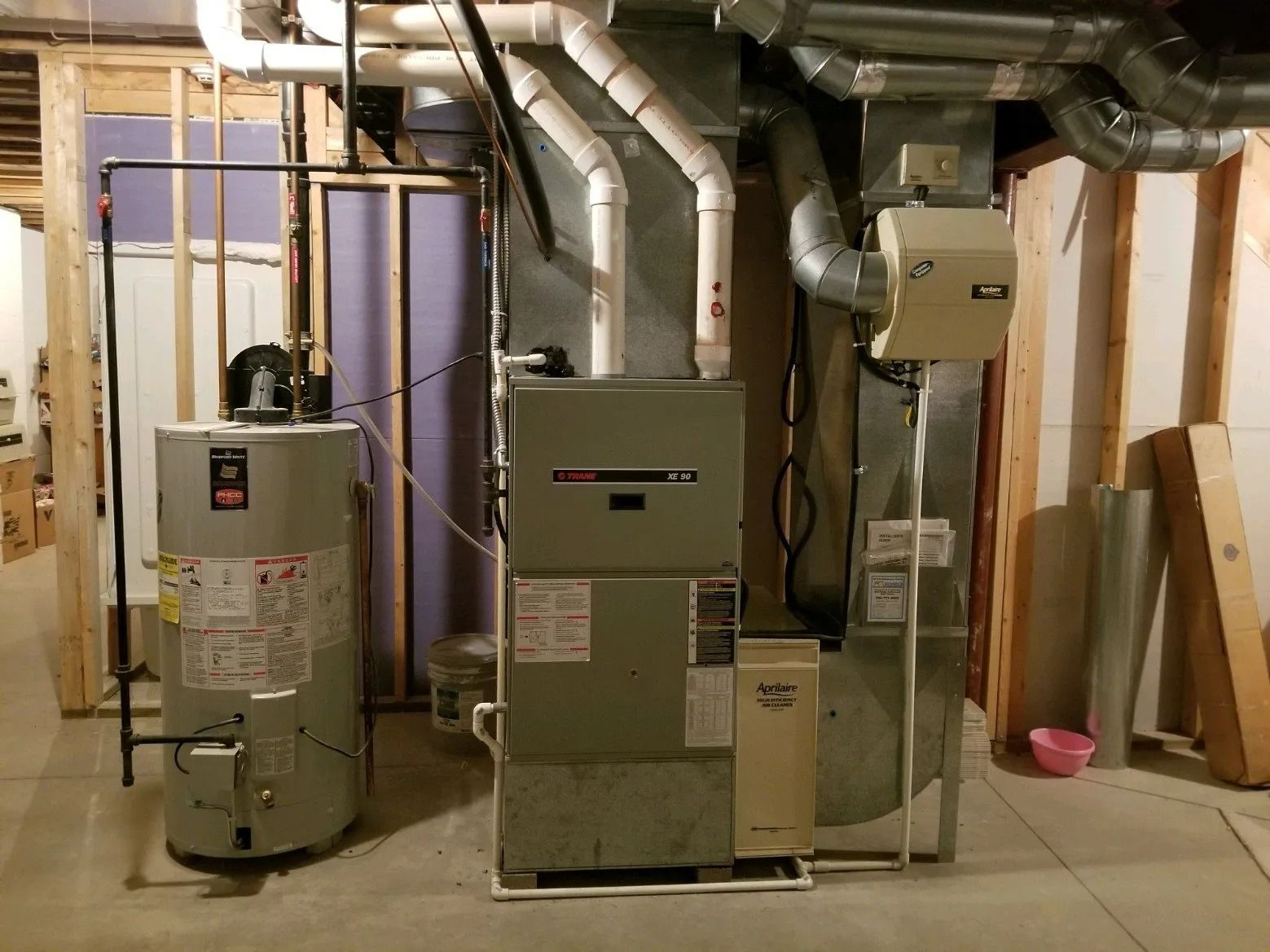 A basement with a water heater and an air conditioner