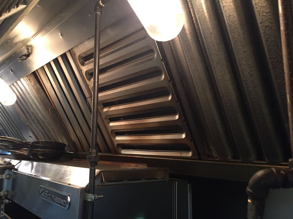 A kitchen with a hood that has a light on it