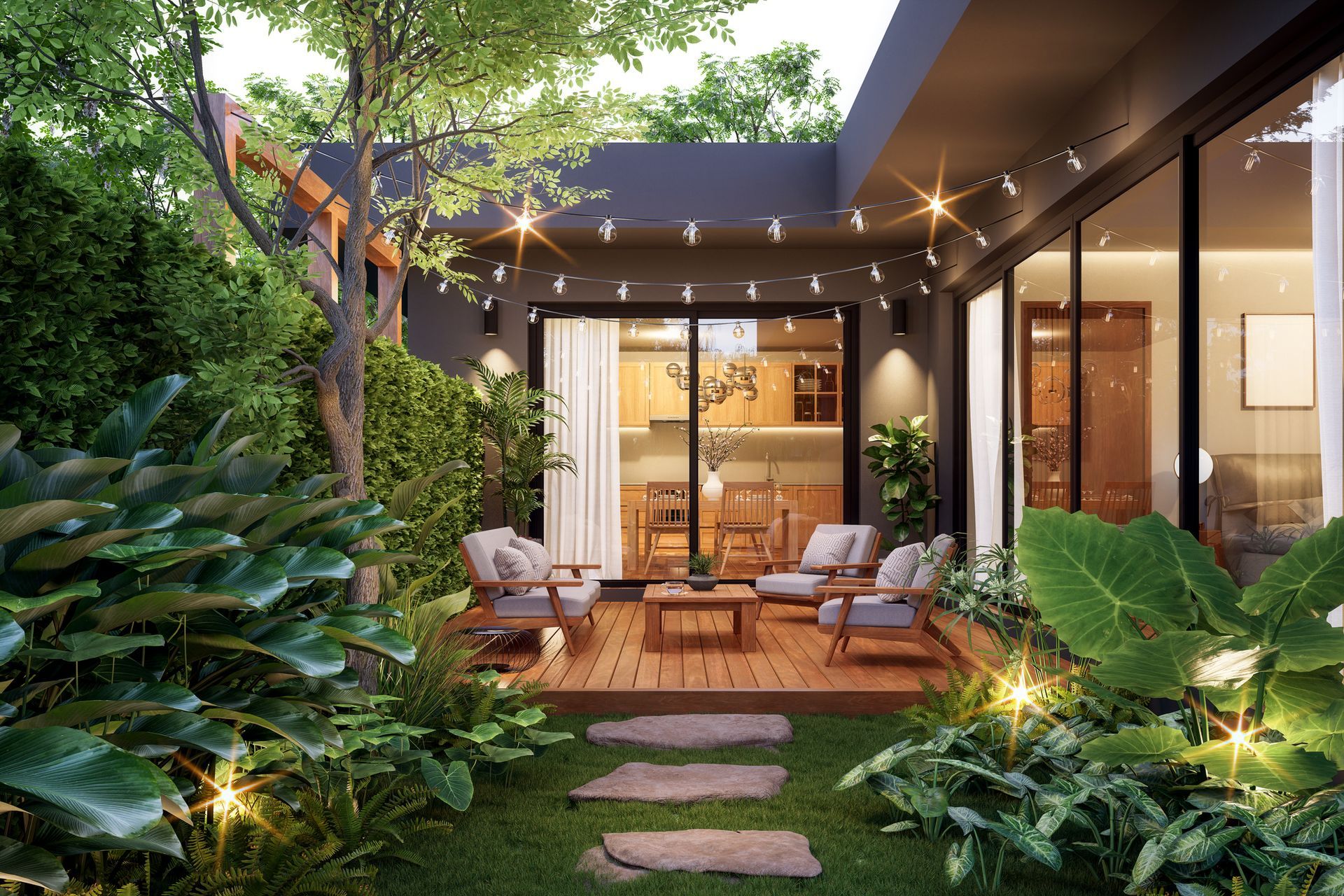 Cozy outdoor patio with wooden deck, seating, and string lights, surrounded by lush green plants and grass.