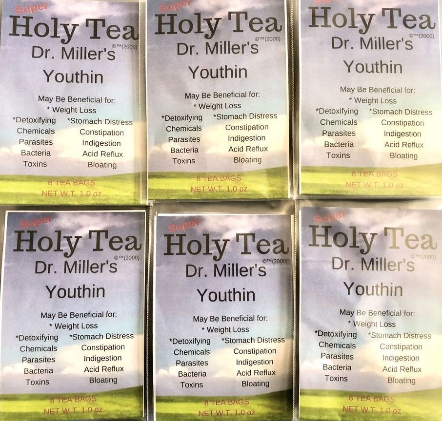 A close up of a purple thistle flower with green leaves.