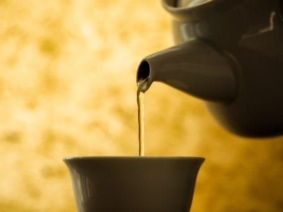 A close up of a teapot pouring tea into a cup