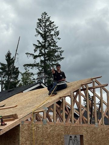 A person holding a baby up in the air indoors near a window, baby smiling.