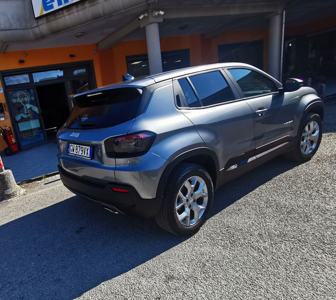 SUV grigio parcheggiato fuori da un negozio al crepuscolo