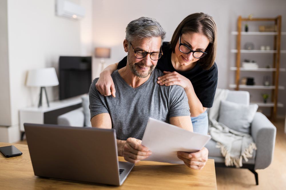 A Man and a Woman Are Looking at a Laptop and a Piece of Paper — Repo Busters Wyong In Newcastle, NSW