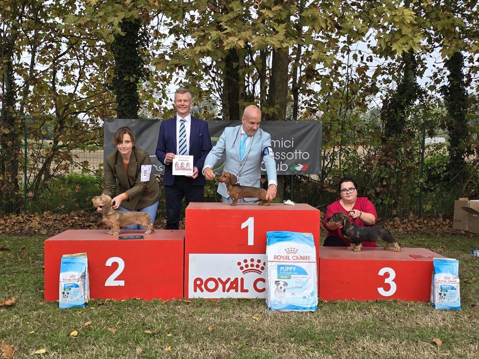 Un gruppo di persone in piedi su un podio con un cane sopra.