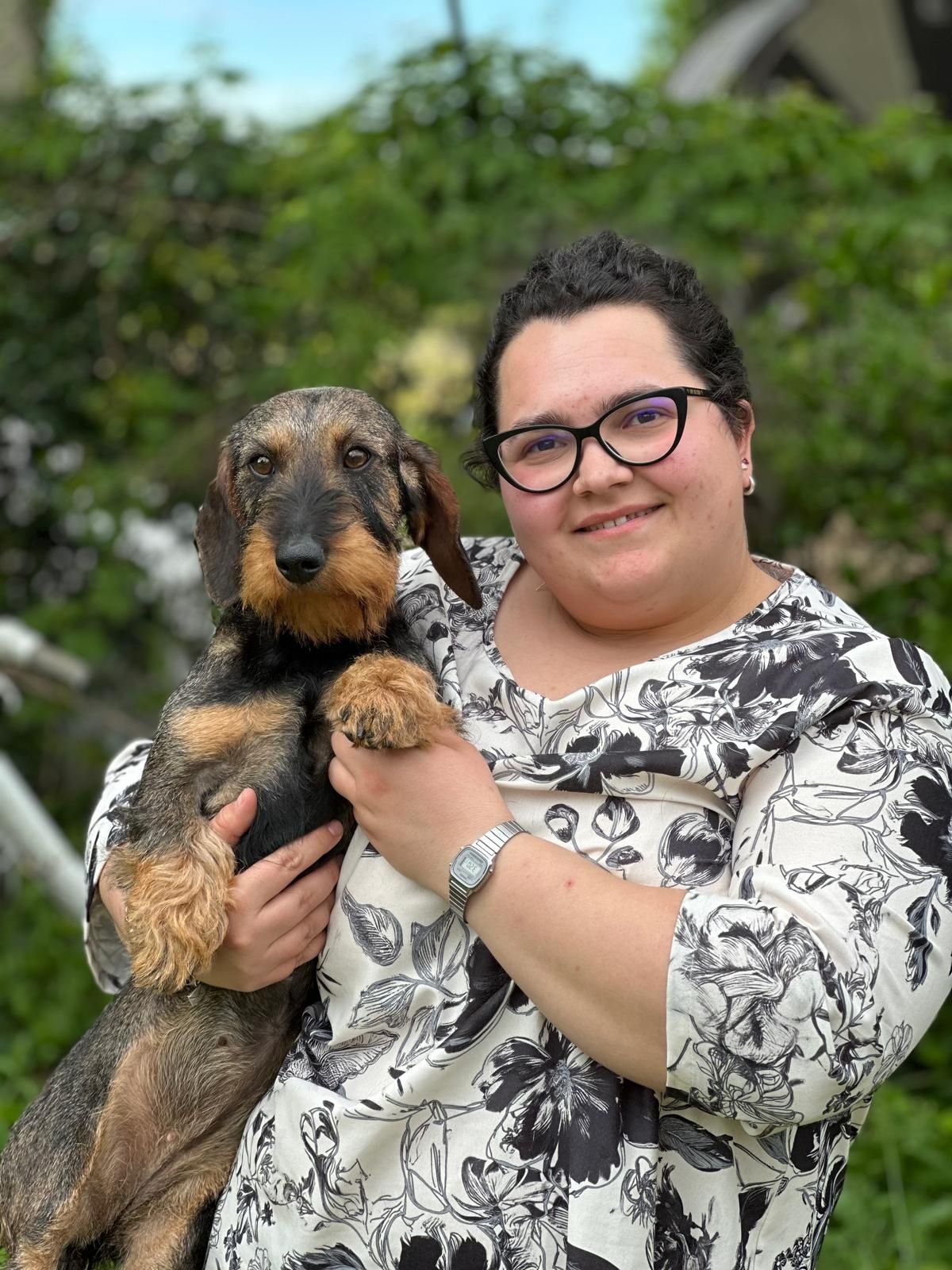Una donna tiene in braccio un cagnolino.
