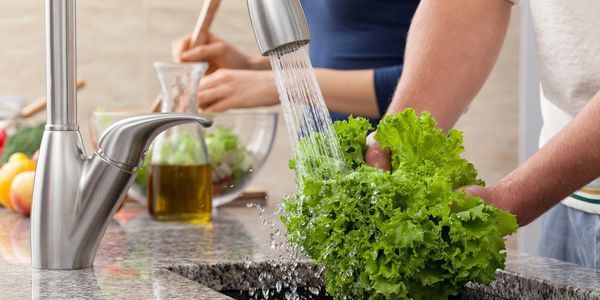 Washing lettuce in sink — Plumbers in Highfields, QLD