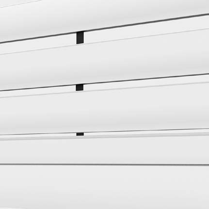 Tende orizzontali bianche con piccole clip nere, parzialmente aperte, in una vista ravvicinata.