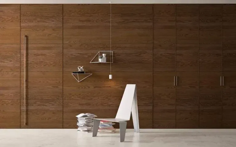 Parete moderna rivestita in legno con maniglie integrate, mensole geometriche e una sedia bianca minimalista.