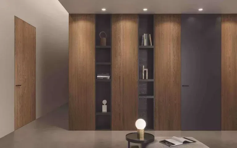 Interno con parete rivestita in legno con ripiani e ante integrati. Un moderno angolo lettura include un tavolino e una lampada.