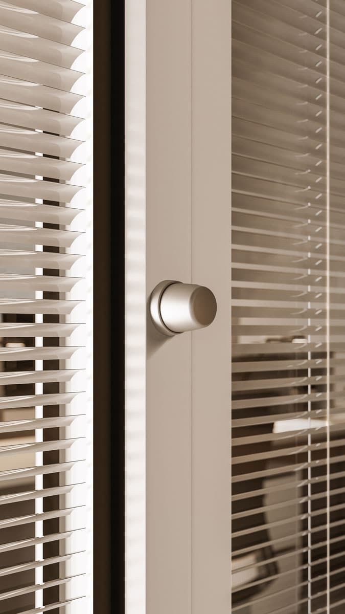 Porta bianca con pomolo cilindrico, fiancheggiata da persiane dietro il vetro.