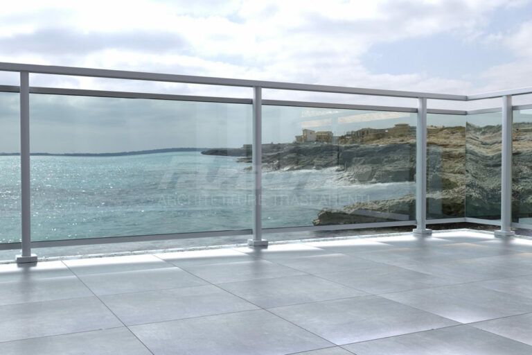 Un balcone moderno con ringhiera in vetro che si affaccia su una costa rocciosa e sull'oceano sotto un cielo nuvoloso.
