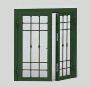 Doppia finestra verde con motivo a griglia nera, una porta leggermente socchiusa.