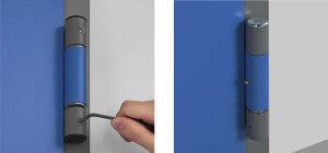 Una mano che usa uno strumento a uncino per regolare la cerniera di una porta blu.