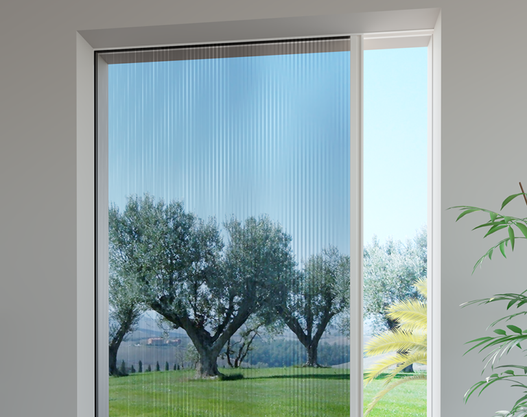 Vista di alberi attraverso una finestra con zanzariera retrattile. La zanzariera è per lo più trasparente con linee verticali. Cielo azzurro brillante.