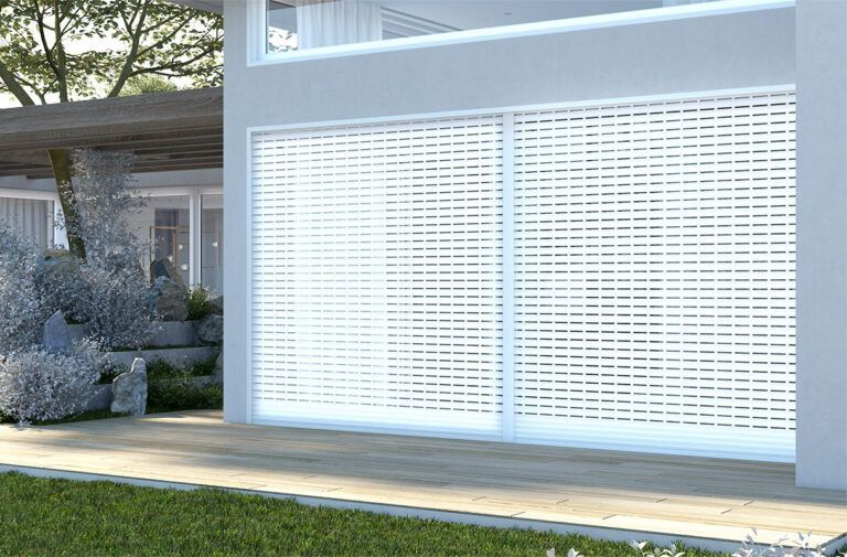 Persiane di sicurezza bianche che coprono una porta scorrevole in vetro in una casa moderna. Ambiente esterno con giardino e terrazza in legno.