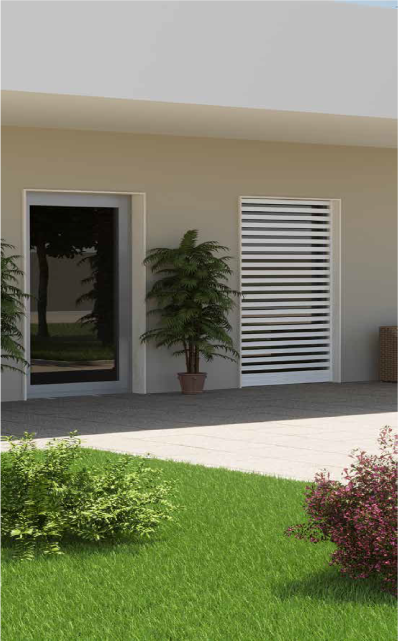 Esterno di un edificio moderno con prato erboso. Presenta una porta a vetri e una finestra con persiane orizzontali bianche, un albero in vaso e un piccolo cespuglio.