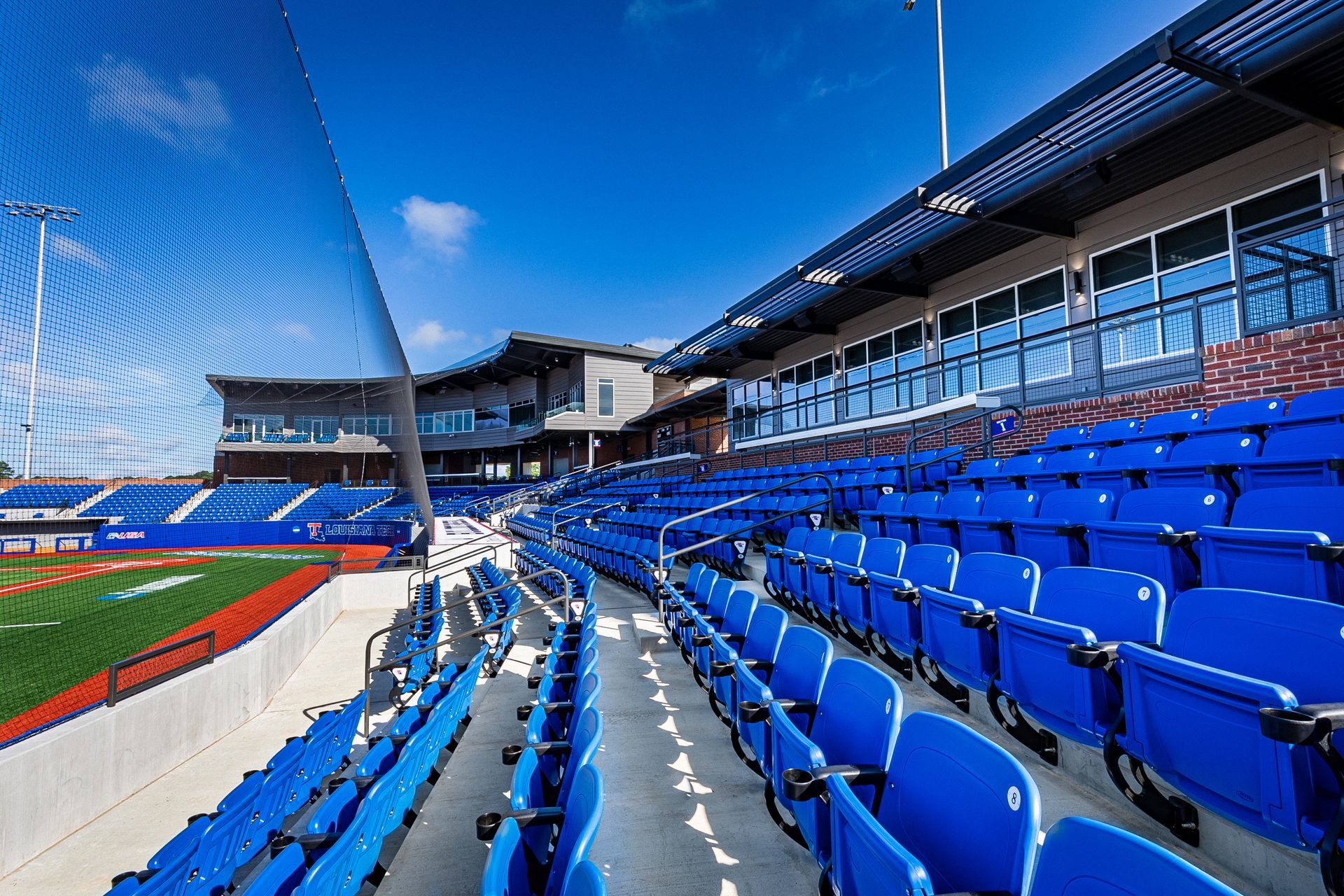 A baseball stadium with rows of blue seats and a baseball field in the background.