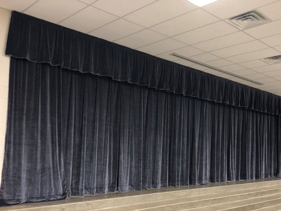A stage with a lot of blue curtains on it