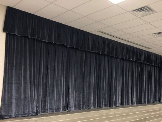 A stage with a lot of blue curtains on it