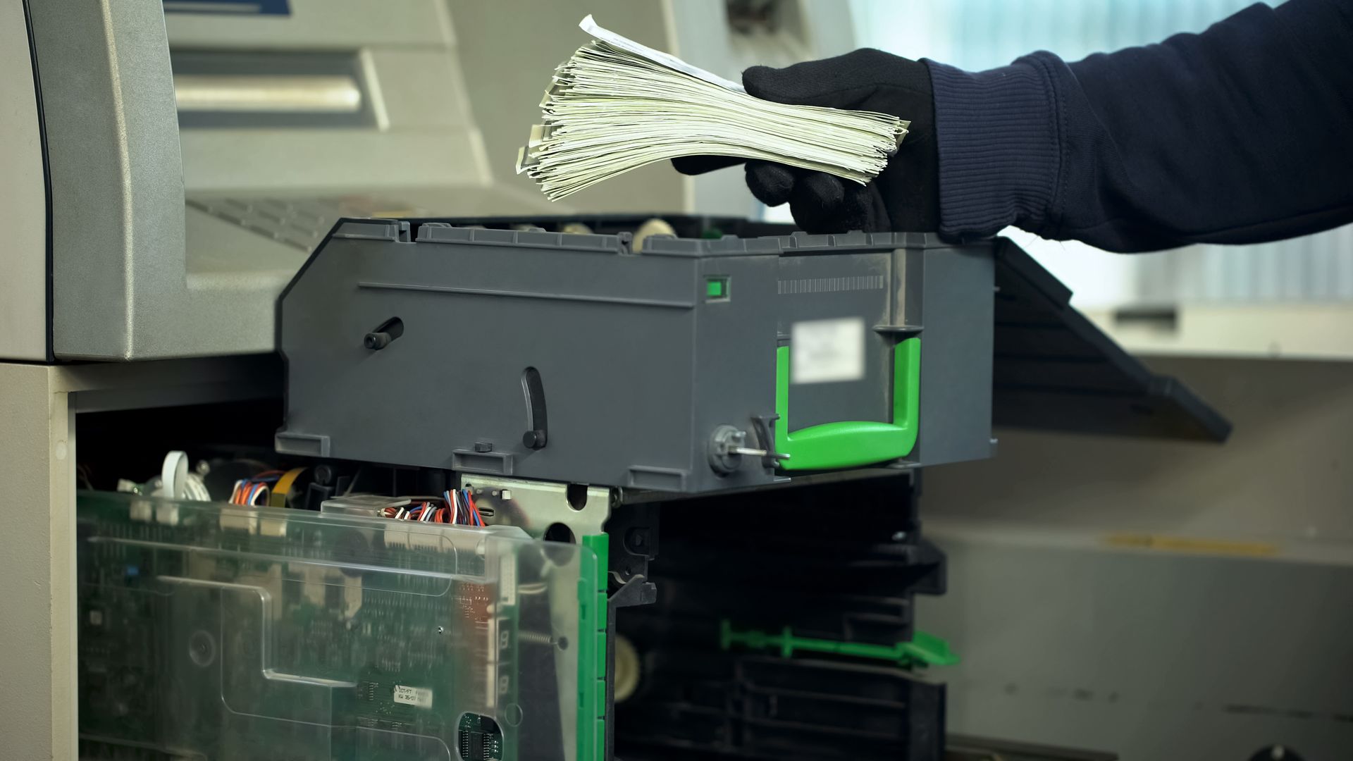 Gloved Hand Placing a Stack of Cash Into an Open ATM Machine — Safe Guard Squad in Lismore, NSW