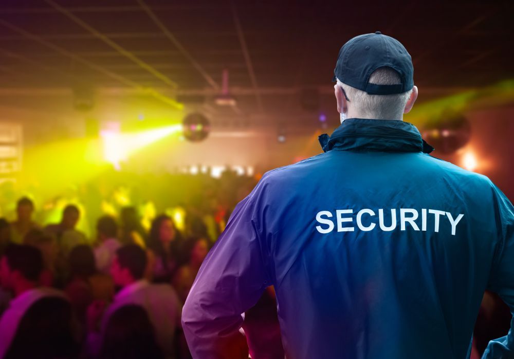 Security Guard in Blue Jacket Watches a Crowded Nightclub with Lights — Safe Guard Squad in Lismore, NSW