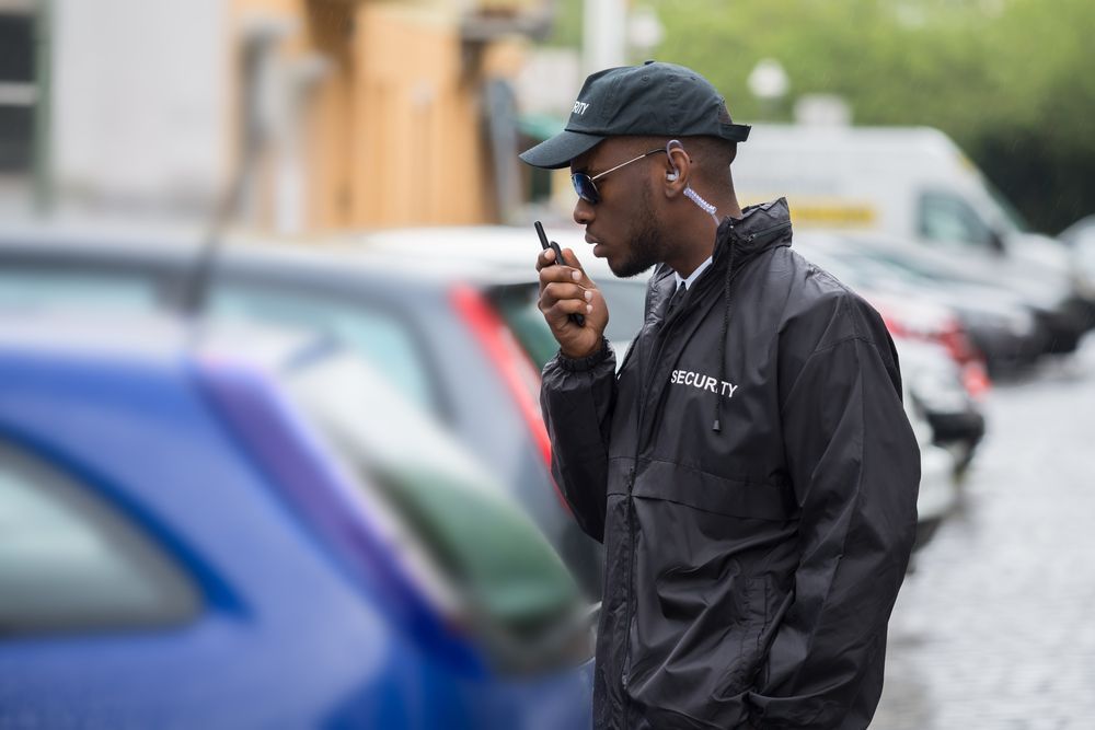 Man in Black Jacket with A Walkie-Talkie Near Parked Cars — Safe Guard Squad in Lismore, NSW