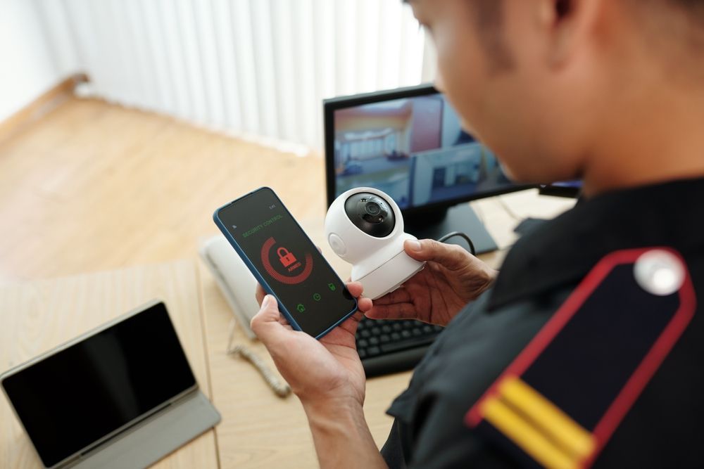 Man Holding Security Camera and Phone — Safe Guard Squad in Byron Bay, NSW 