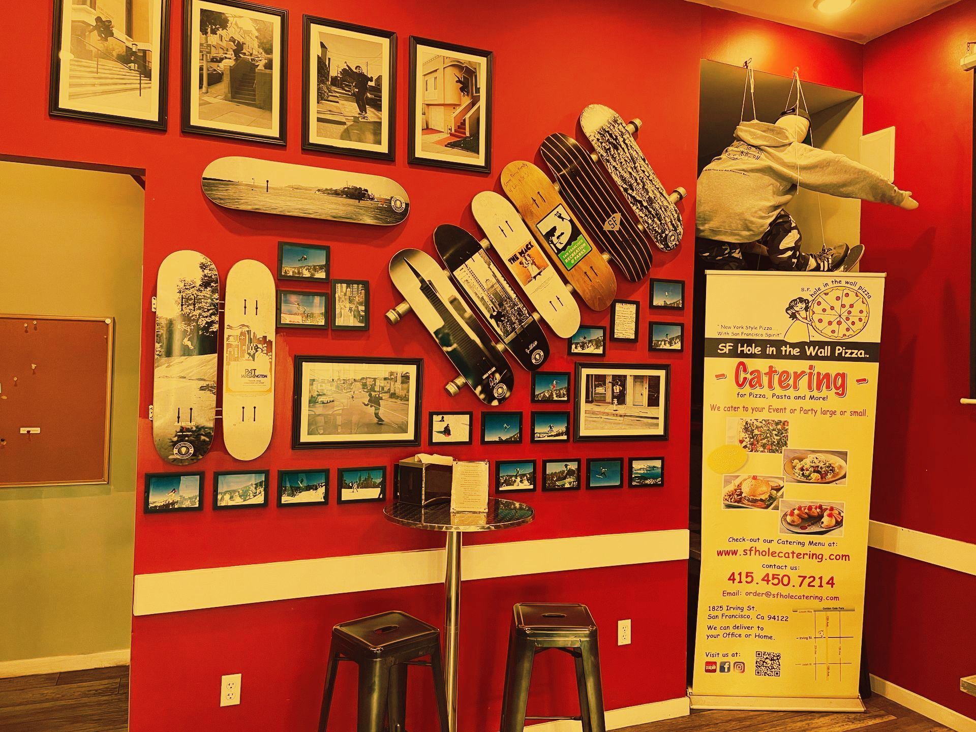 A red wall with skateboards on it and a sign that says catering