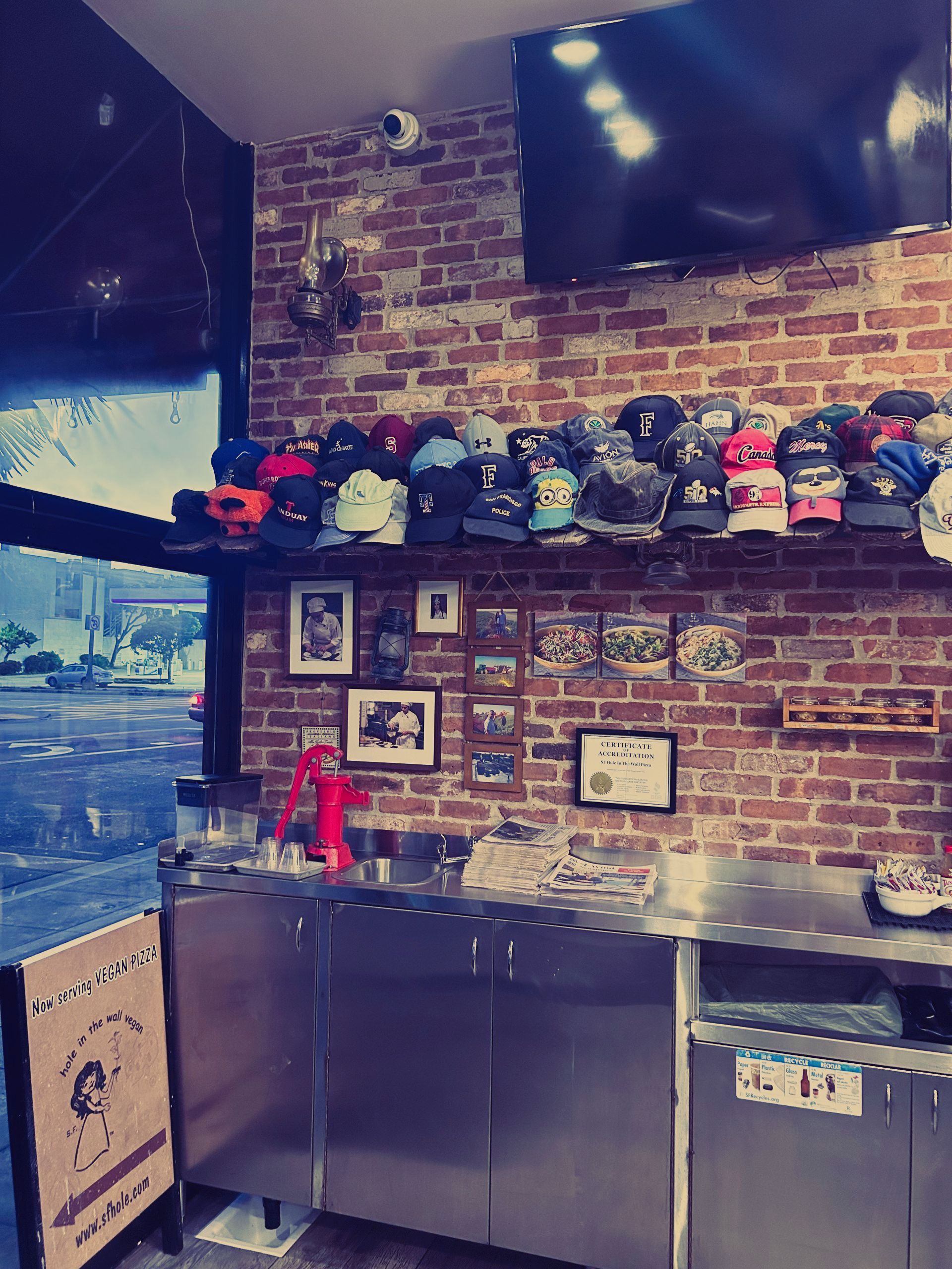 A brick wall with a lot of hats on it