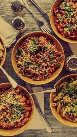 A table topped with bowls of pasta