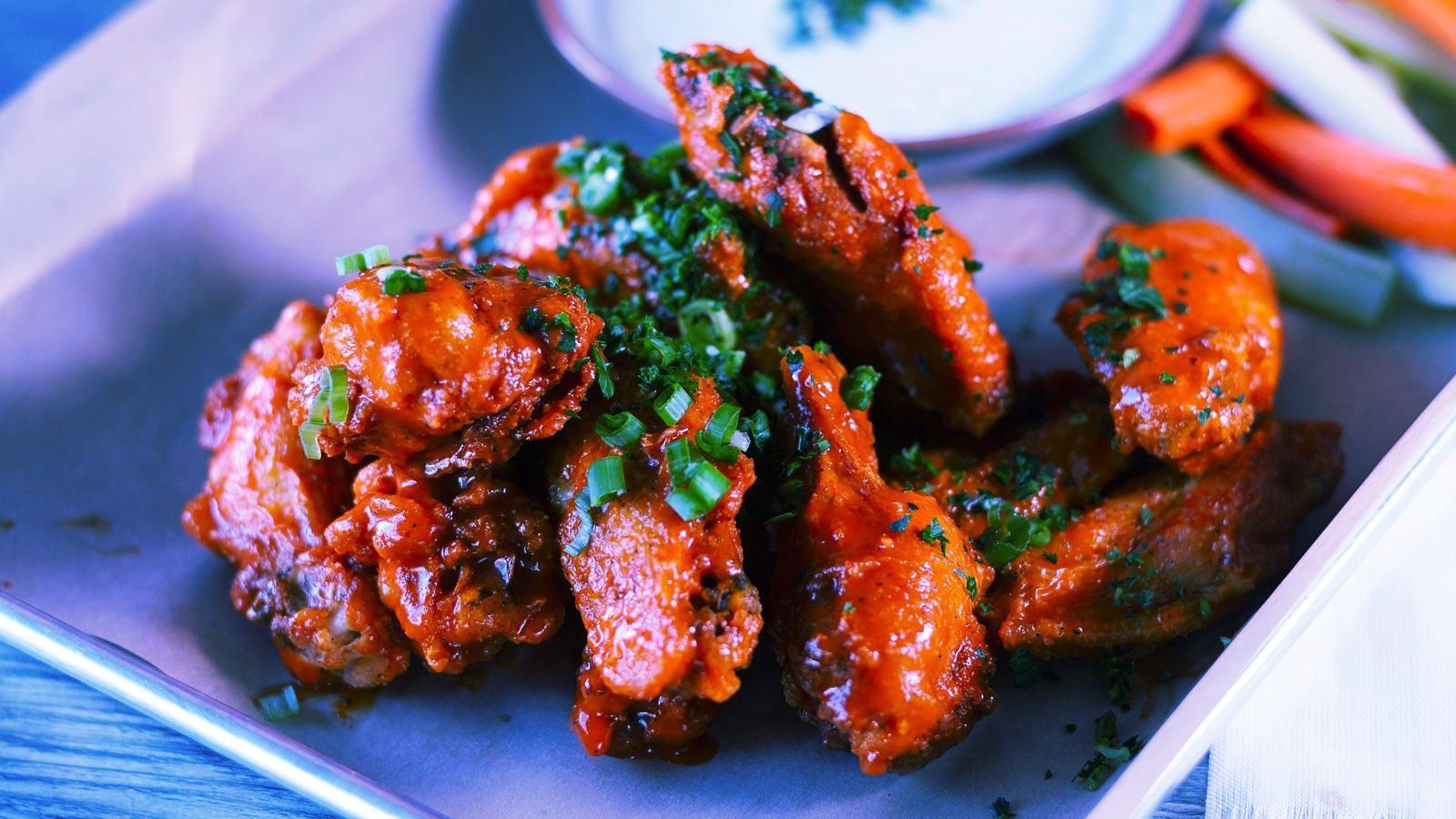 A close up of a plate of chicken wings on a table