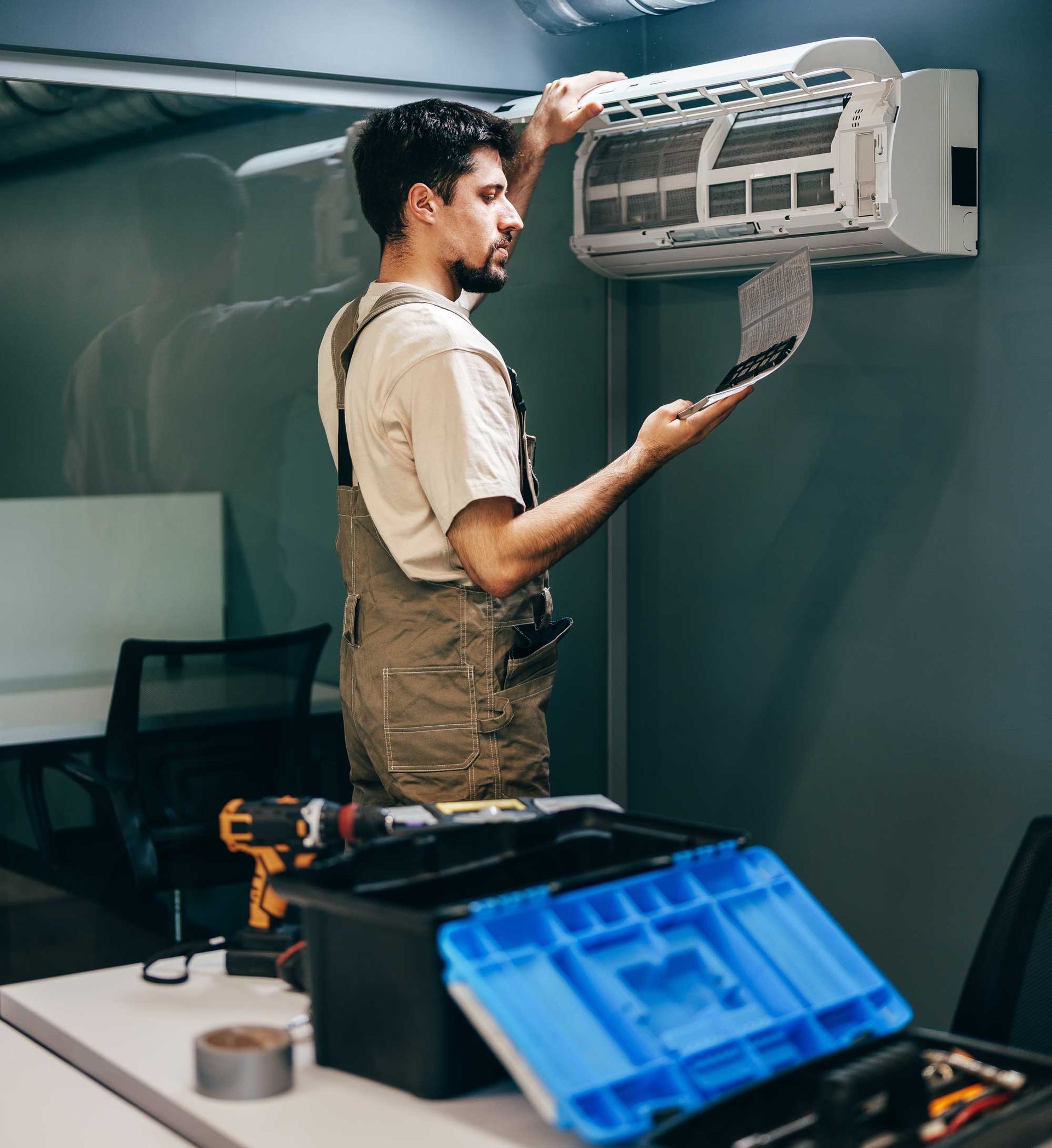 Technician performs maintenance on air conditioning.