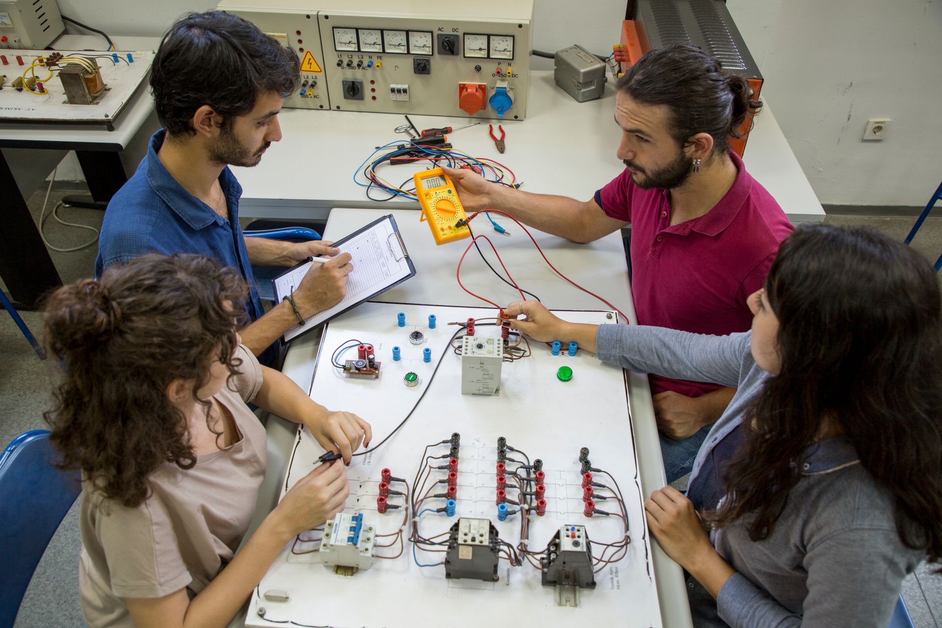 Students receiving hands-on electrical training in a trade school lab setting.
