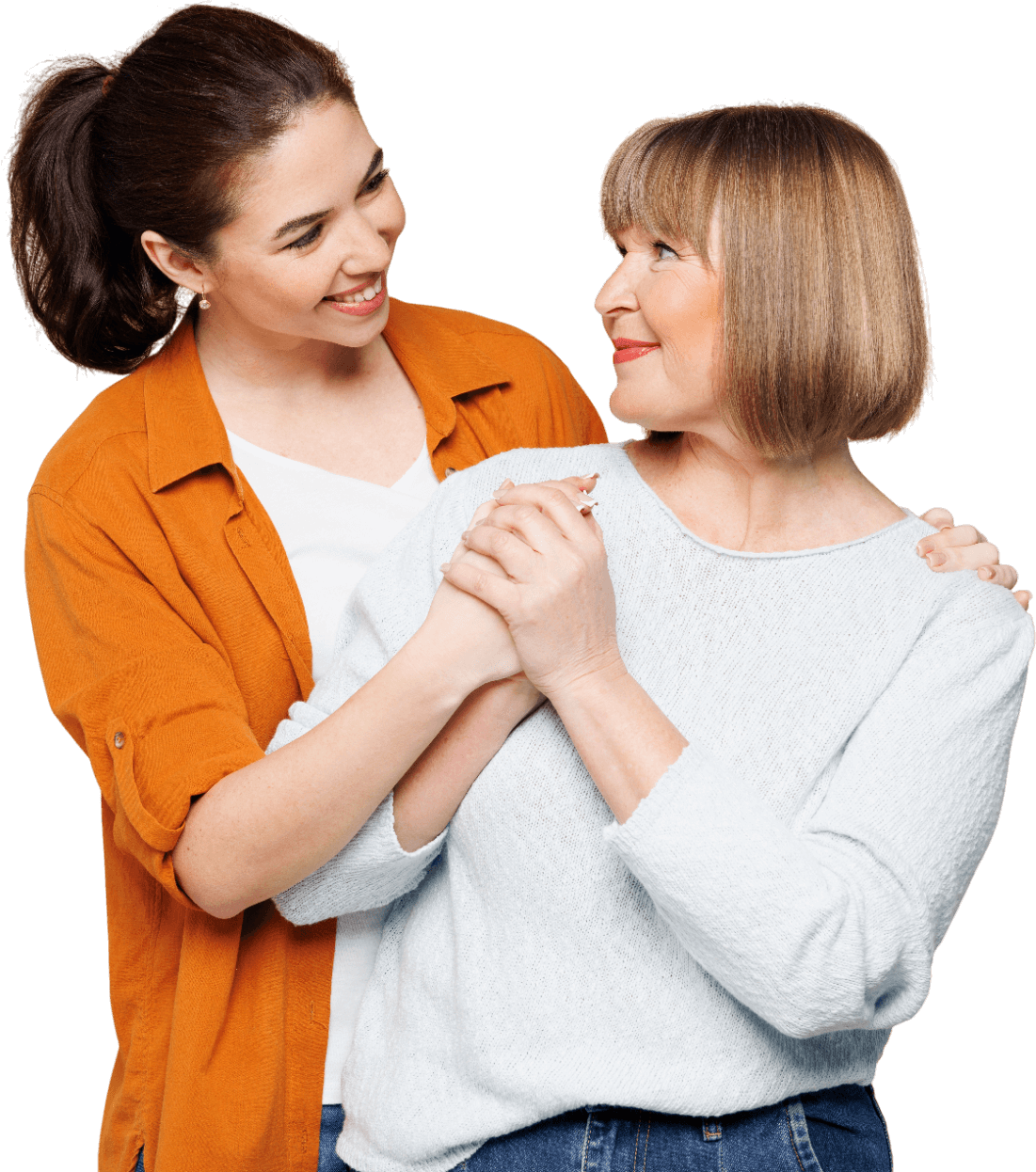 Young woman with her hands on the older woman's hands, smiling and looking at her with affection.