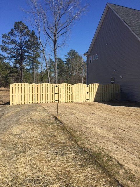 A wooden fence is in front of a house