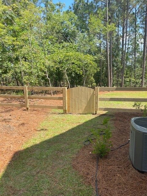 There is a wooden fence and a gate in the backyard.