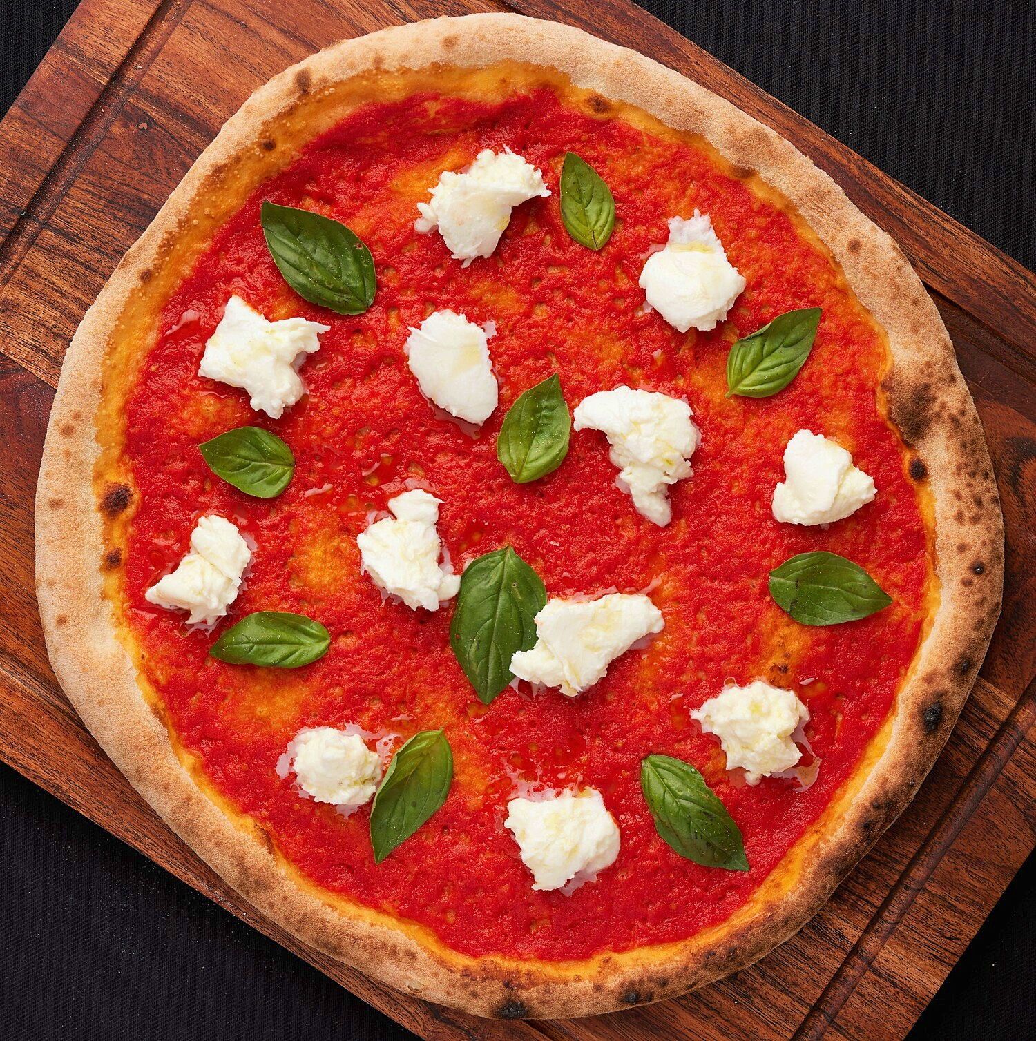 a pizza with tomato sauce and basil on it