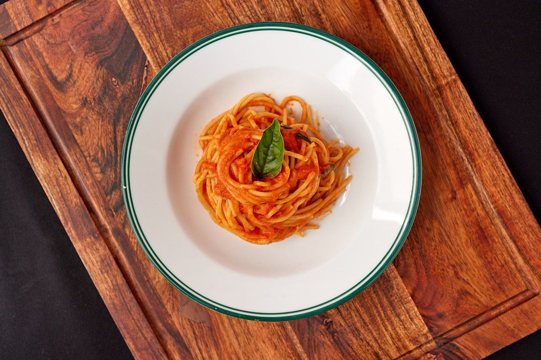 a white plate topped with spaghetti and tomato sauce