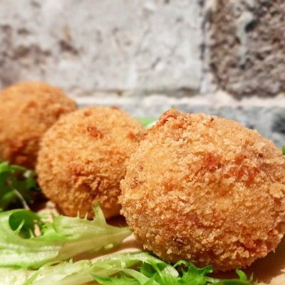 a close up of Arancini on a plate with lettuce .