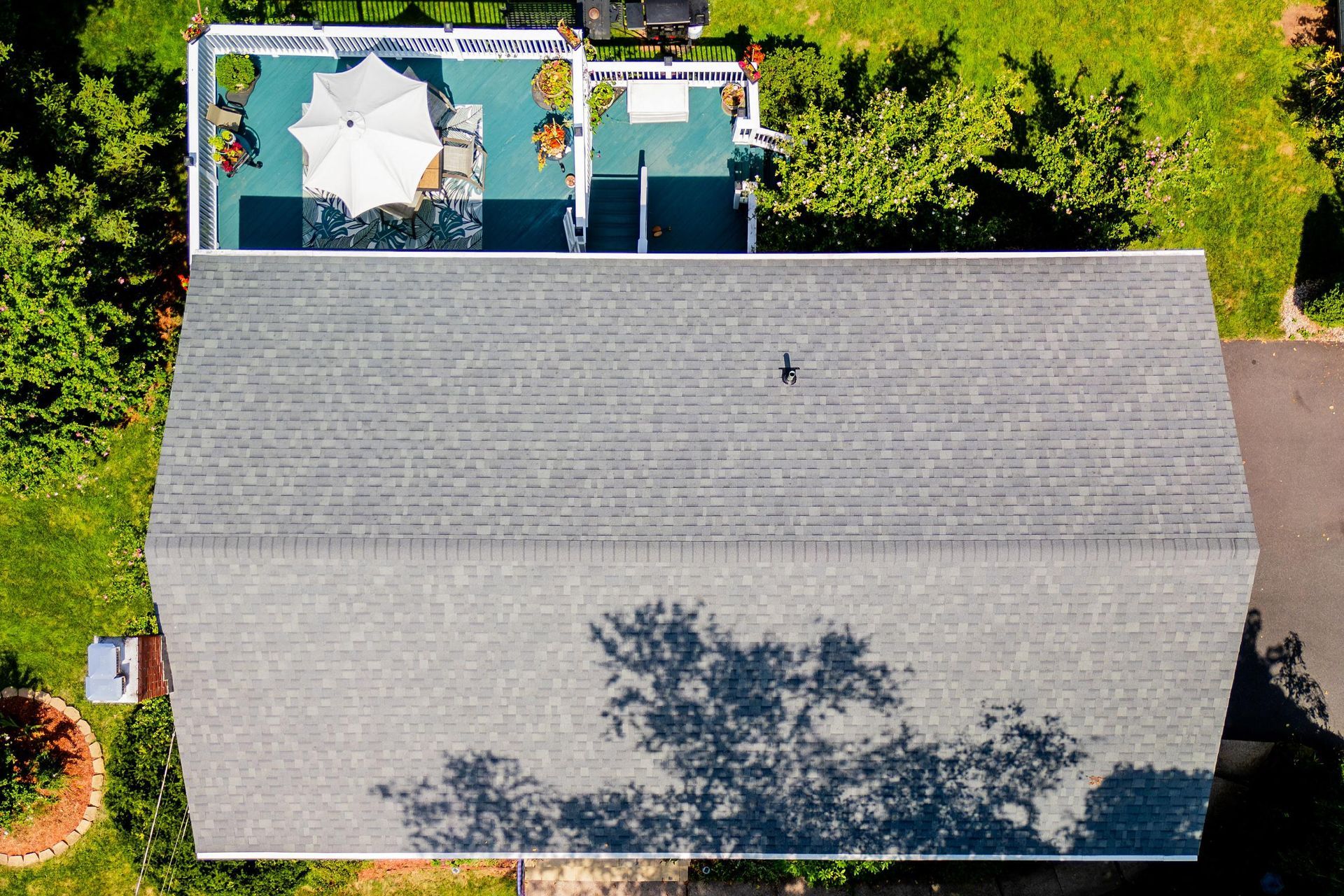 An aerial view of a house with a pool and umbrella on the roof.