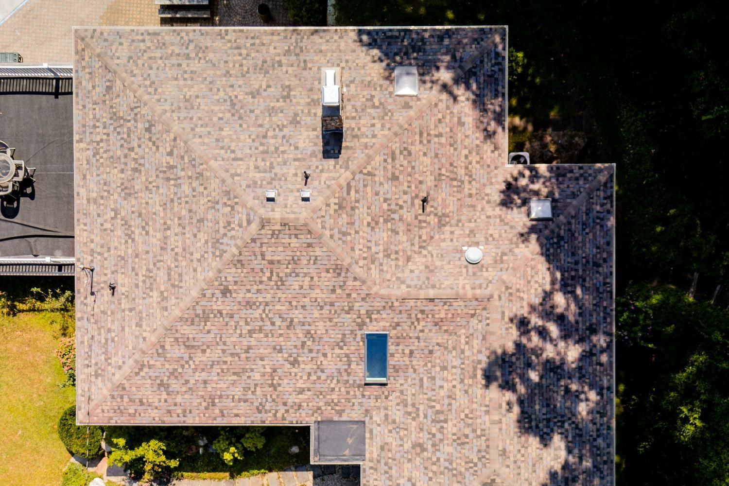 An aerial view of a roof of a house with a skylight.