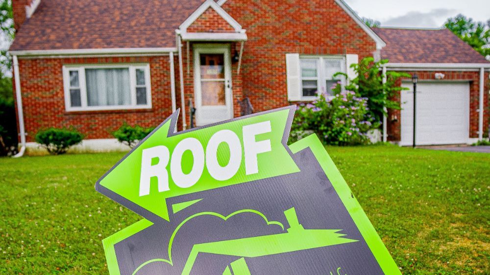 An A1 Home Improvement roof sign is sitting in front of a brick house.