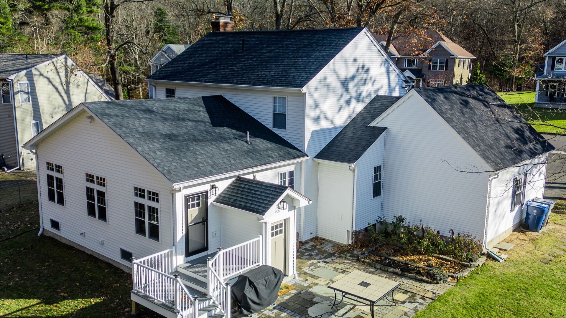 An aerial view of a white house with a black roof.