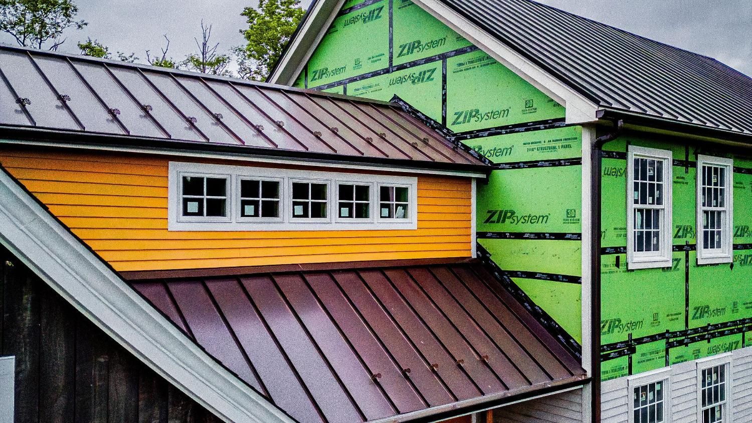 A house with a metal roof is being built.