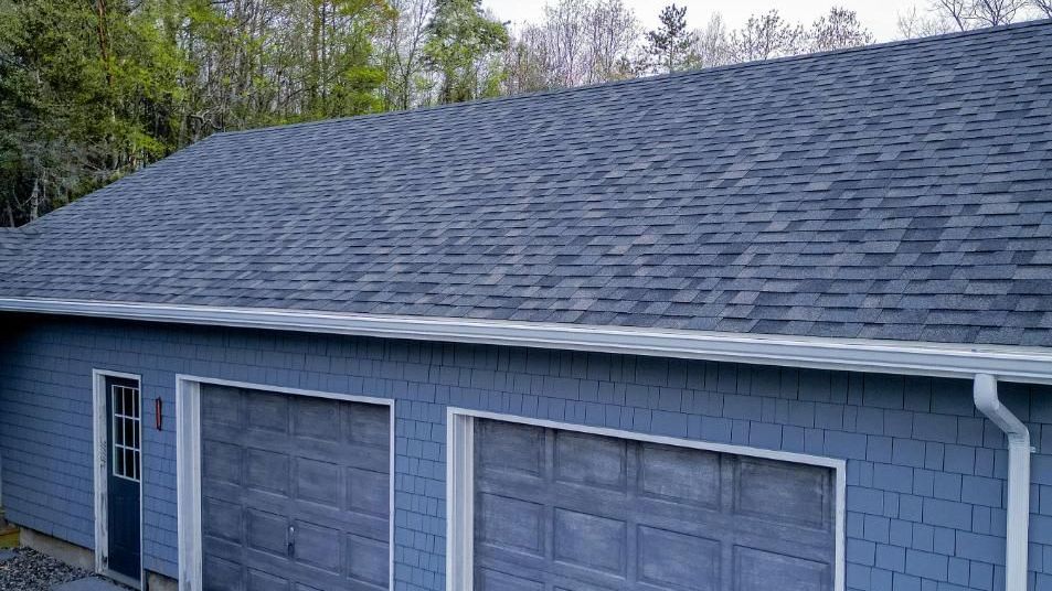 A modern garage featuring a meticulously installed asphalt shingle roof