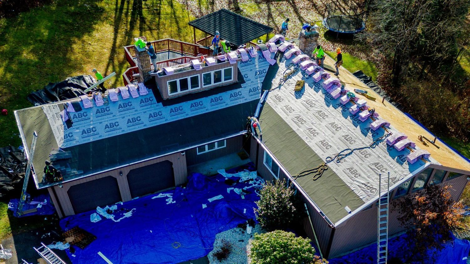 An aerial view of a house being remodeled with a roof being installed.