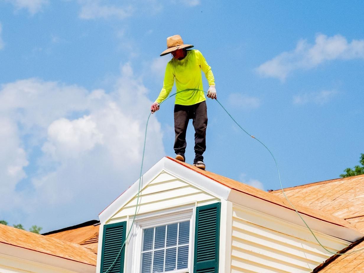 Professional roofer inspecting a damaged roof