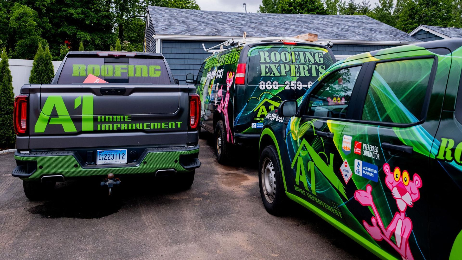 Two roofing experts trucks are parked in front of a house.