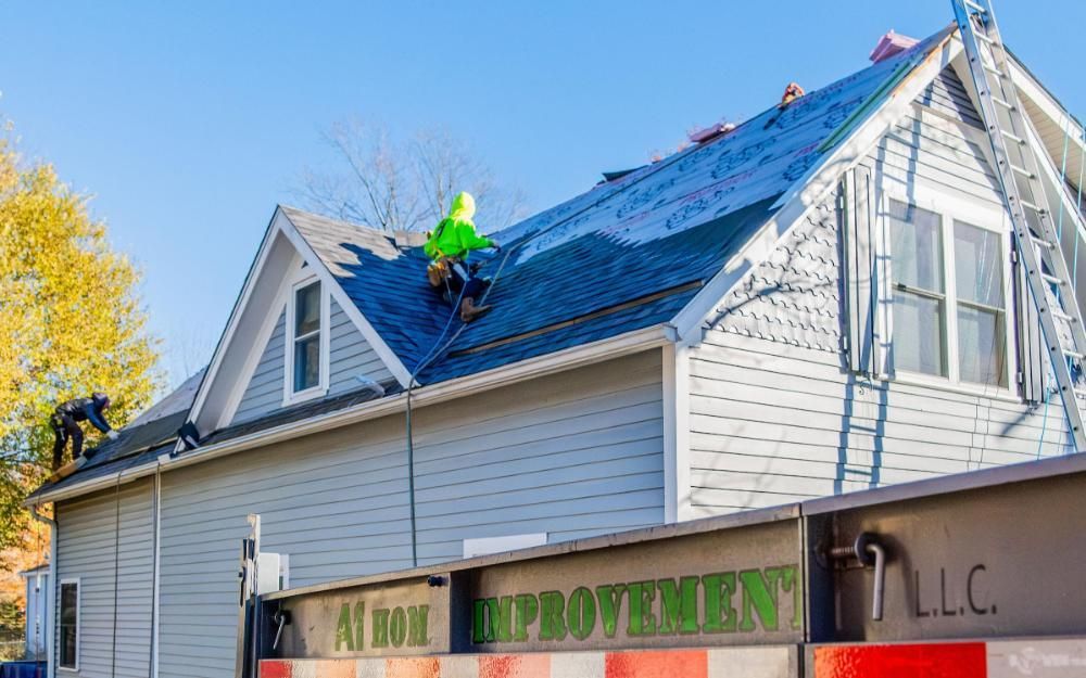 A man working fixing a leak on an asphalt roof